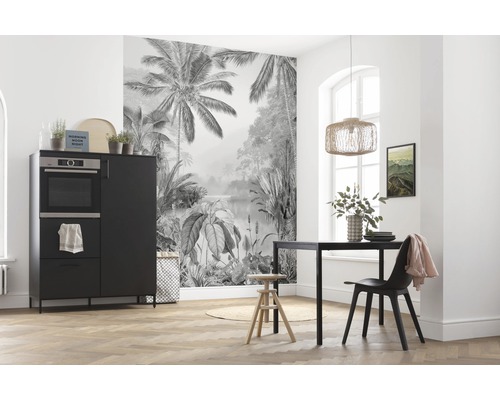 Salle à manger avec table à manger, chaise et buffet noirs devant un papier peint photo avec un motif de jungle.