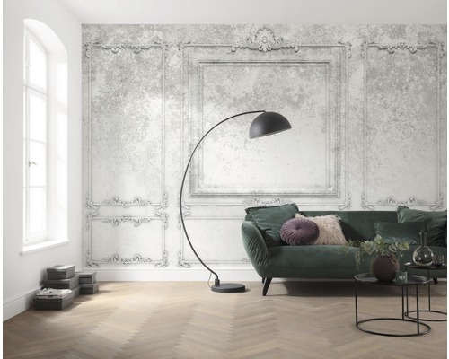 Salon lumineux avec papier peint à motifs de cadre ornemental, canapé, lampadaire et parquet