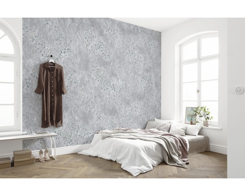 Chambre lumineuse avec papier peint à motifs, lit et parquet