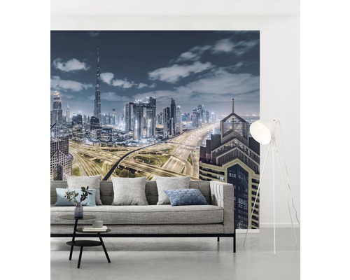 Wohnraum mit Fototapete einer Skyline bei Nacht und grauer Couch