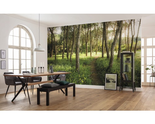 Salle à manger avec papier peint forêt, table à manger et banc pour une atmosphère proche de la nature.