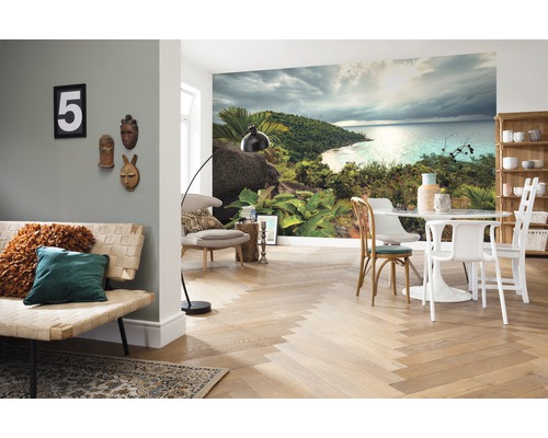 Salon avec papier peint photo d''une île tropicale, un canapé, une table et des chaises.