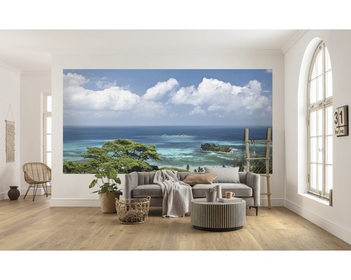 Salon avec papier peint photo d''un panorama côtier avec vue sur la mer et ciel nuageux