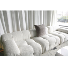 Salon lumineux avec grand canapé modulable et coussin