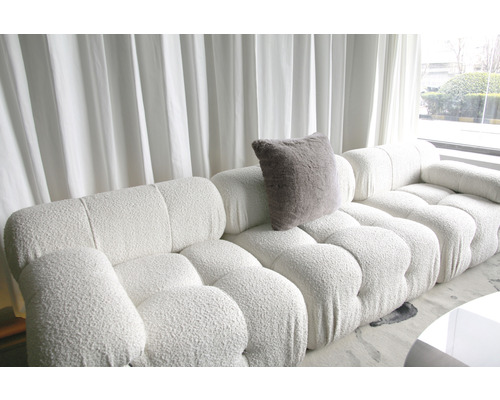 Salon lumineux avec grand canapé modulable et coussin