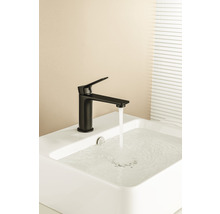 Robinet noir sur un lavabo blanc avec de l''eau qui coule.