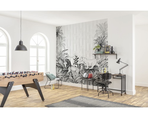 Salon lumineux avec un papier peint photo à motifs de jungle, un baby-foot et un bureau