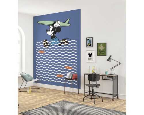 Espace de vie avec une peinture murale de Mickey Mouse, un bureau et une chaise.