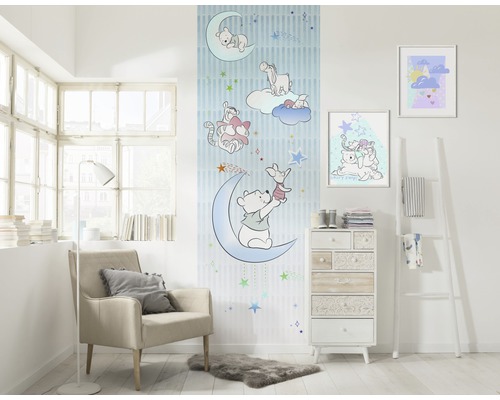 Vue d''une pièce avec du papier peint Winnie l''ourson, un fauteuil, une commode et de la décoration