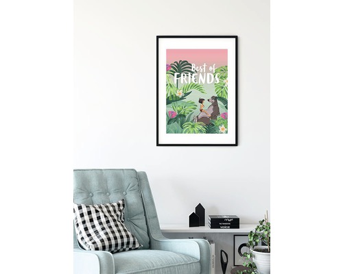 Une image encadrée pour chambre d''enfant avec un motif de jungle et l''inscription Meilleurs amis est accrochée à un mur blanc au-dessus d''un fauteuil.