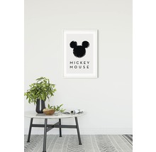 Dekorativer Kunstdruck mit Mickey Mouse Motiv im Rahmen an der Wand über einem Tisch mit Dekoration.