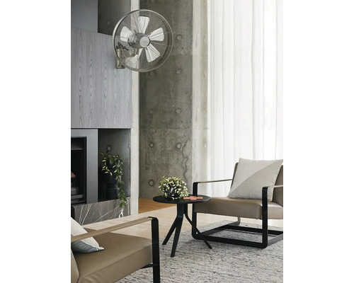 Wohnzimmer mit Wandventilator, Sessel und Beistelltisch