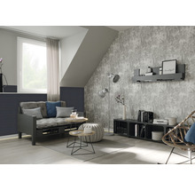 Wohnzimmer mit Schlafsofa, Beistelltischen, Stehlampe und gemusterter Tapete