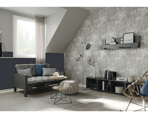 Wohnzimmer mit Schlafsofa, Beistelltischen, Stehlampe und gemusterter Tapete