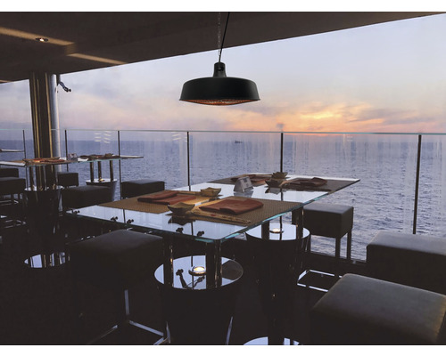 Restaurantterrasse mit Tischen, Hockern und Deckenheizstrahler