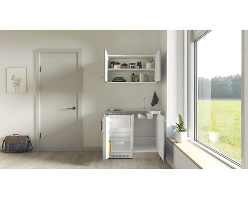 Cuisine compacte avec évier, plaque de cuisson et réfrigérateur dans un appartement lumineux.