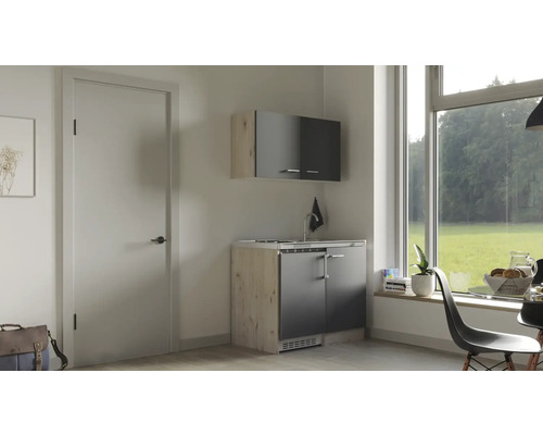 Petite cuisine avec évier, meuble bas et meuble haut dans une pièce lumineuse.