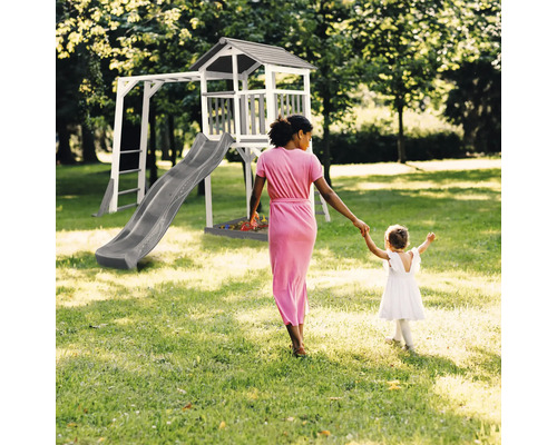 Tour de jeux avec toboggan, échelle et bac à sable dans le jardin