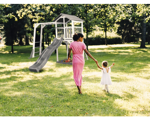 Aire de jeux avec tour de jeux, toboggan et portique d''escalade dans le jardin