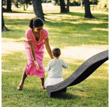Mère et enfant près d''un toboggan dans le jardin.