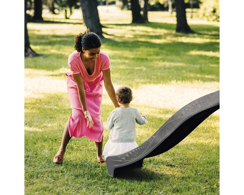 Mère et enfant près d''un toboggan dans le jardin.