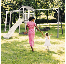 Aire de jeux avec tour, toboggan et balançoire pour enfants dans le jardin