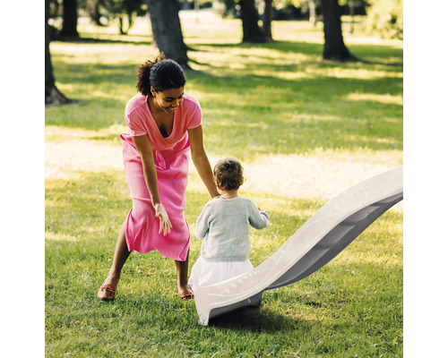 Femme et enfant à un toboggan dans le jardin.