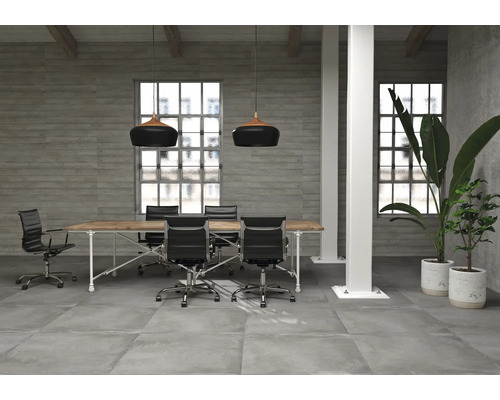 Bureau moderne avec table de conférence, chaises de bureau, sol en béton et suspensions.