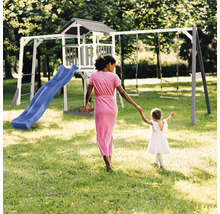 Spielplatz mit Schaukel, Rutsche und Spielhaus im Garten mit Frau und Kind.