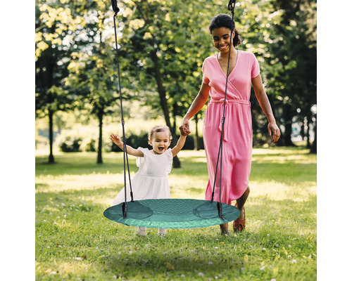 Mère et enfant avec balançoire de jardin ronde à l''extérieur