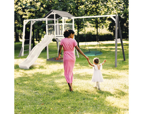 Spielplatz mit Turm, Rutsche und Schaukel für Kinder im Garten.