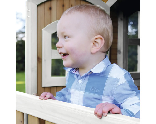 Enfant riant dans une cabane en bois