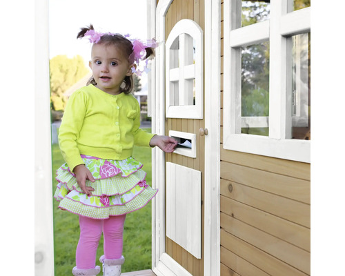 Mädchen steckt Brief in Briefkasten an einem Spielhaus