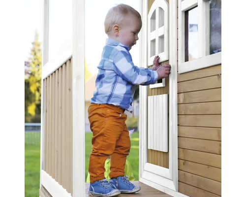 Petit enfant entrant dans une cabane en bois
