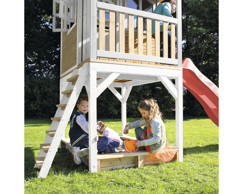 Maisonnette avec toboggan et bac à sable avec des enfants jouant dans le jardin