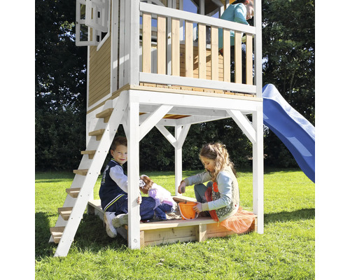 Tour de jeu avec toboggan et bac à sable avec des enfants jouant dans le jardin.