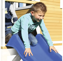 Enfant glissant sur un toboggan bleu d''une cabane de jeu.
