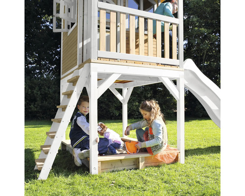 Tour de jeu avec toboggan, échelle et bac à sable pour enfants dans le jardin.