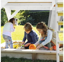 Kinder spielen im Sandkasten mit Dach und Leiter im Garten.