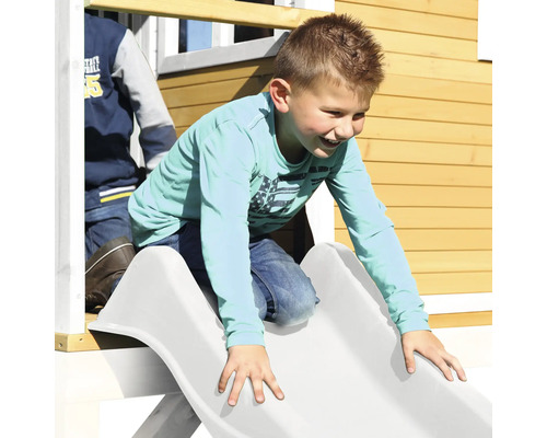 Garçon glissant sur un toboggan d''une cabane de jeux