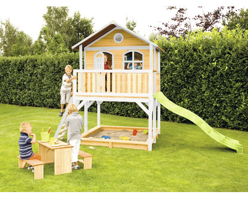 Maisonnette avec bac à sable, toboggan et table de pique-nique pour enfants dans le jardin.