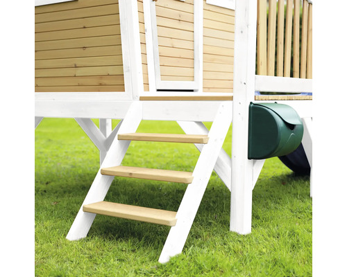 Detailansicht eines Spielhauses mit Holzfassade, Treppe und Briefkasten im Garten