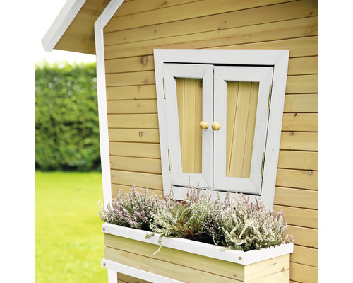 Detailansicht eines Holzspielhauses mit Fenster, Fensterladen und Blumenkasten