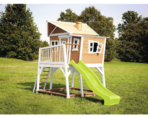 Cabane en bois avec toboggan dans le jardin.
