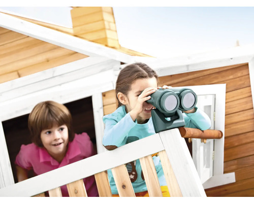 Deux enfants jouent dans une cabane en bois, dont un avec des jumelles.