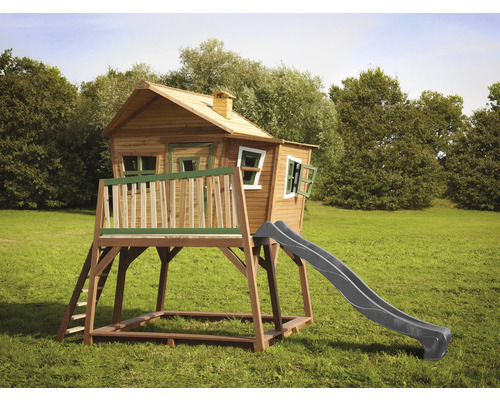 Maisonnette en bois avec toboggan et échelle sur une pelouse