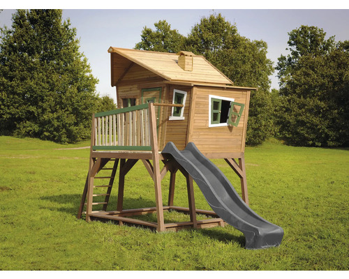 Cabane de jeux avec toboggan et échelle sur une pelouse