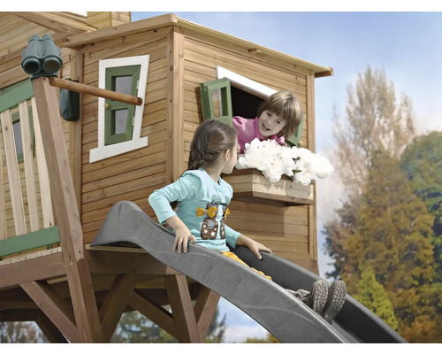 Cabane de jeux avec toboggan et deux enfants jouant dans le jardin