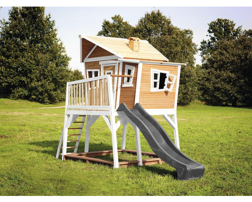 Maison de jeu en bois avec toboggan et échelle dans le jardin