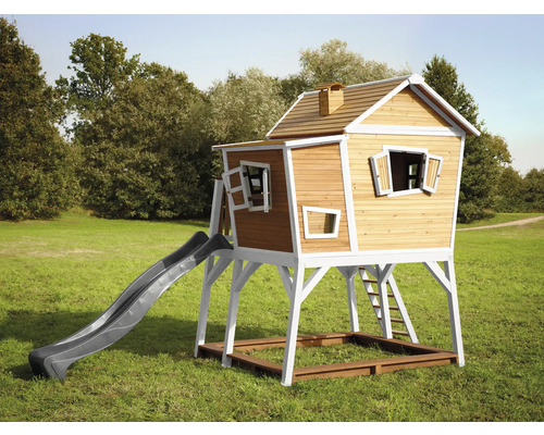 Maisonnette en bois avec toboggan et bac à sable sur une pelouse